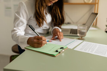 Accountant with statistical documents taking notes at office