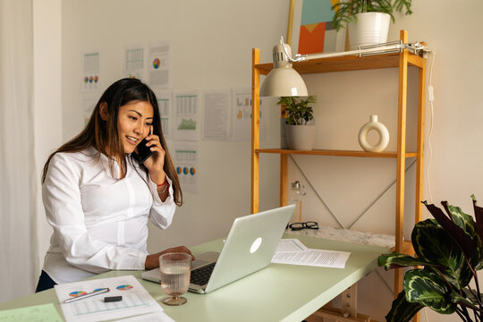 Asian woman making call from work office