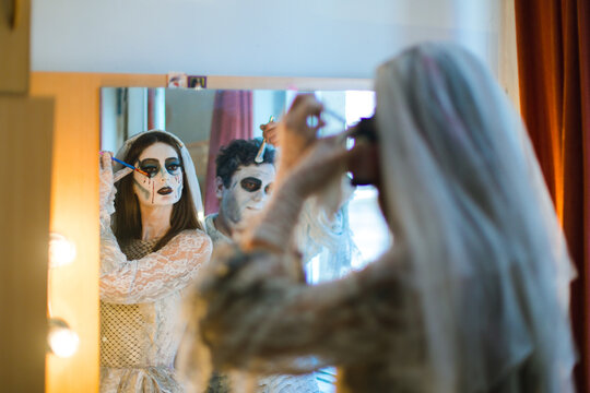 Actors  in front of a mirror make themselves make-up
