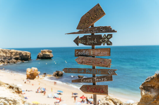 Wooden direction sign near sandy seashore