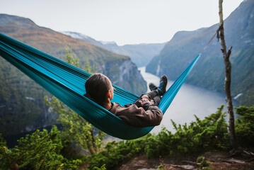 Man resting in hammock above Geirangerfjord in Norway