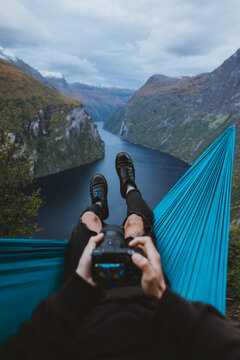 Photographer resting in hammock above river valley 