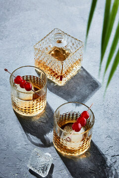 Whiskey Cocktails  with Decanter Under Palm Leaves