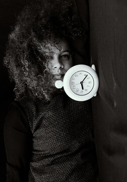 Black and white portrait of young woman with clock