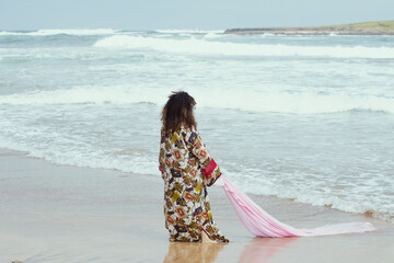 Young girl with curly hair on the water at the beach 