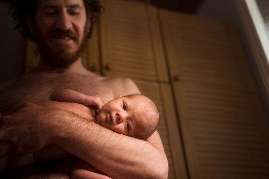 Smiling father holding cute newborn