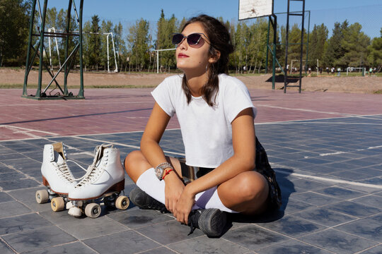 Pretty girl riding on in-line skates on a basketball court