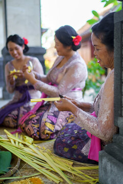 Balinese family preparing offerings for praying rituals
