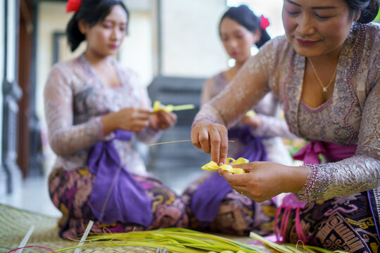 Balinese family preparing flower offerings for Hindu temple