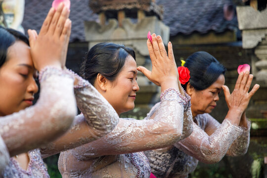 Balinese family praying together wearing traditional clothes