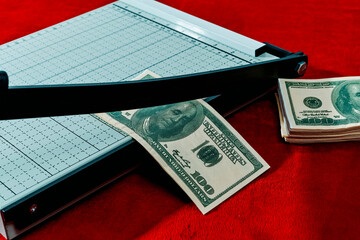 cutting a fake 100 dollar baknote