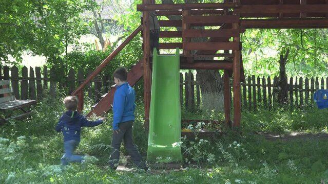 Siblings slide down together in train style