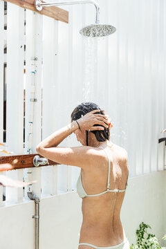 Woman Washing Hair In Swim Wear Outdoors