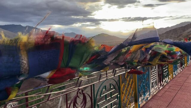 Buddhist flags flutter in the wind at monastery on  mountain overlooking the Tibetan Indian city of Leh