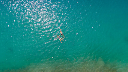 young couple floating, drone selfie in the sea