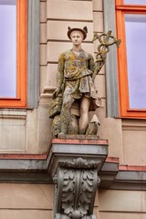 Statue of Hermes or Mercury in Riga Old town, covered in lichen and moss 