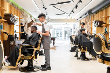 Two Barbers Working With Their Clients