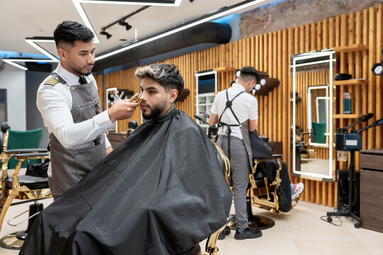 Barbers Working With Their Clients At Salon