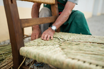 senior craftsman making a chair with bayon