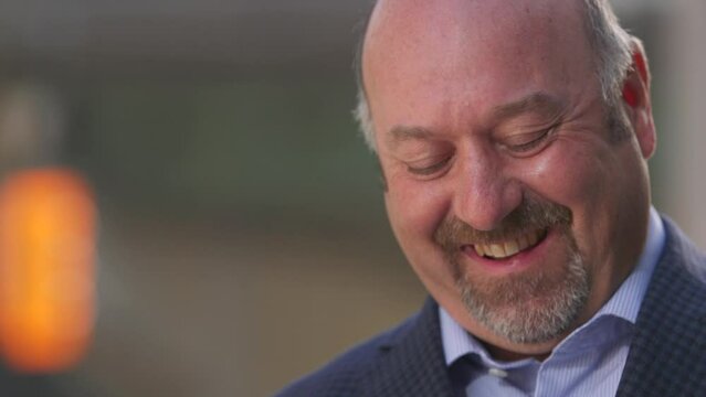 Close up of man reading text message and smiling and laughing