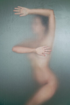 Silhouette of a young naked woman in a shower room
