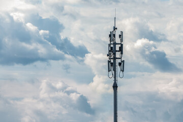 Obraz premium Cellular network transmission tower on cloudy sky background, copy space