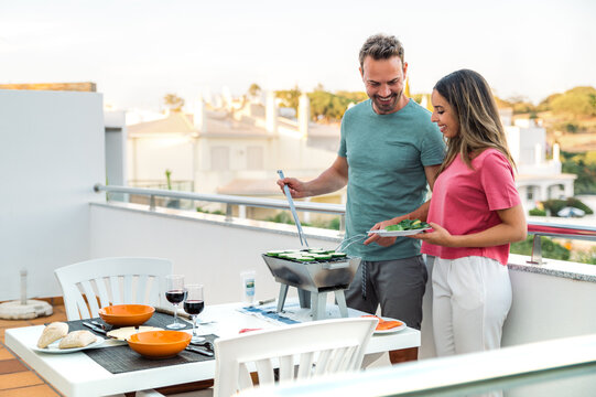 Loving couple preparing healthy dinner on terrace