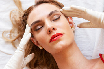 Beautiful blond lady in red dress lying on floor