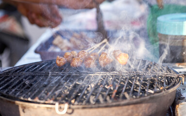 Indonesian food - Grilled meatballs ( Bakso Bakar) grilling outdoors on a barbaecue grill.