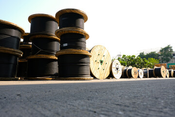 Wooden Coils Of Electric Cable Outdoor. High and low voltage cables in the storage.