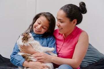 mother and daughter playing with their pet cat