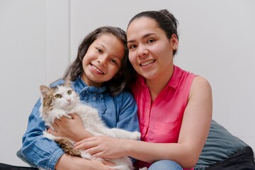 mother and daughter playing with their pet cat