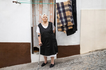 portrait of elderly woman at the door of her house