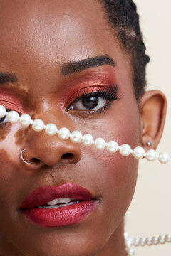 Close Up Image of Young Black Woman with Vitiligo Holding Pearls