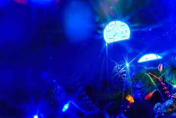 Obraz na płótnie Canvas Holiday blue bokeh garlands in a blur, in the dark on a tree.