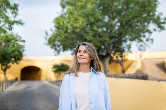 elegant mature woman walking through a charming town