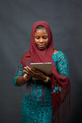 An African Nigerian muslim lady, student or businesswoman with a scarf called hijab on her head,...