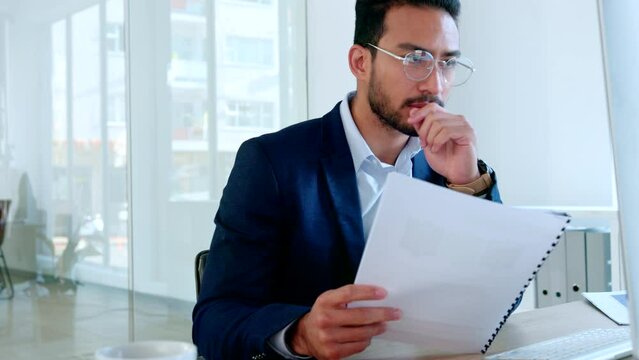 Data analyst reading paperwork sitting marketing statistics reports. Serious businessman looking thoughtful while analyzing information and thinking of idea to be innovative for his next project