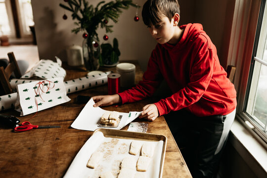 boy wrapping homemade shortbread cookies for Christmas 
