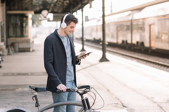 Boy Listening To Music At Train Station