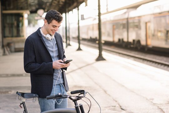 Boy Standing With Bike At Train Station