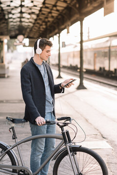 Boy Listening To Music At Train Station