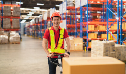 asian male warehouse worker Work at a distribution center looking at camera Standing at a large warehouse, the new arrival of additional items in the warehouse department. Employees , organize