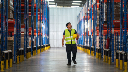 male warehouse worker Working at a distribution center, walking and looking at the products. Analyze new arrivals of additional items in the warehouse department. Employees who organize the distributi