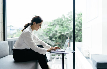 Asian woman working with laptop in her office. business financial concept.