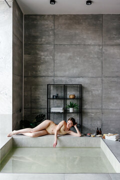 Relaxed woman lying on pool border in spa center