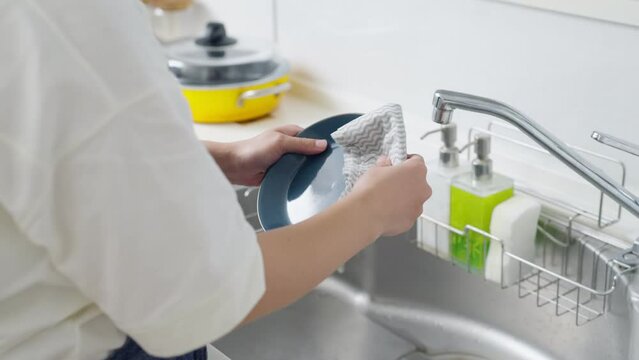 60p　キッチンで皿を拭く女性（家事・主婦）