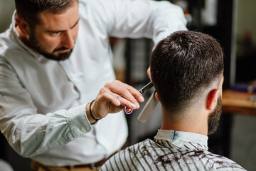 Hairdresser using clippers to cut hair
