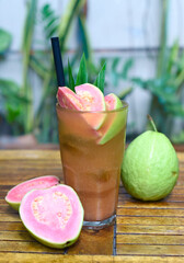 Pink guava ice tea on wooden planks background 