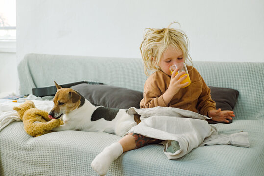 Little boy drinking orange juice while sick